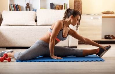 La chica hace deporte en casa.